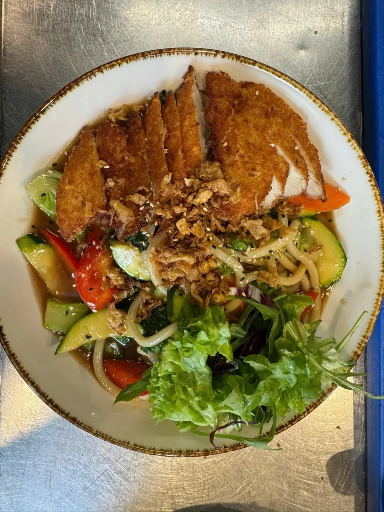 Aromatische Udon-Nudeln mit knusprig gebratener Hähnchenbrust und Gemüse – asiatische Spezialität bei Do Friends