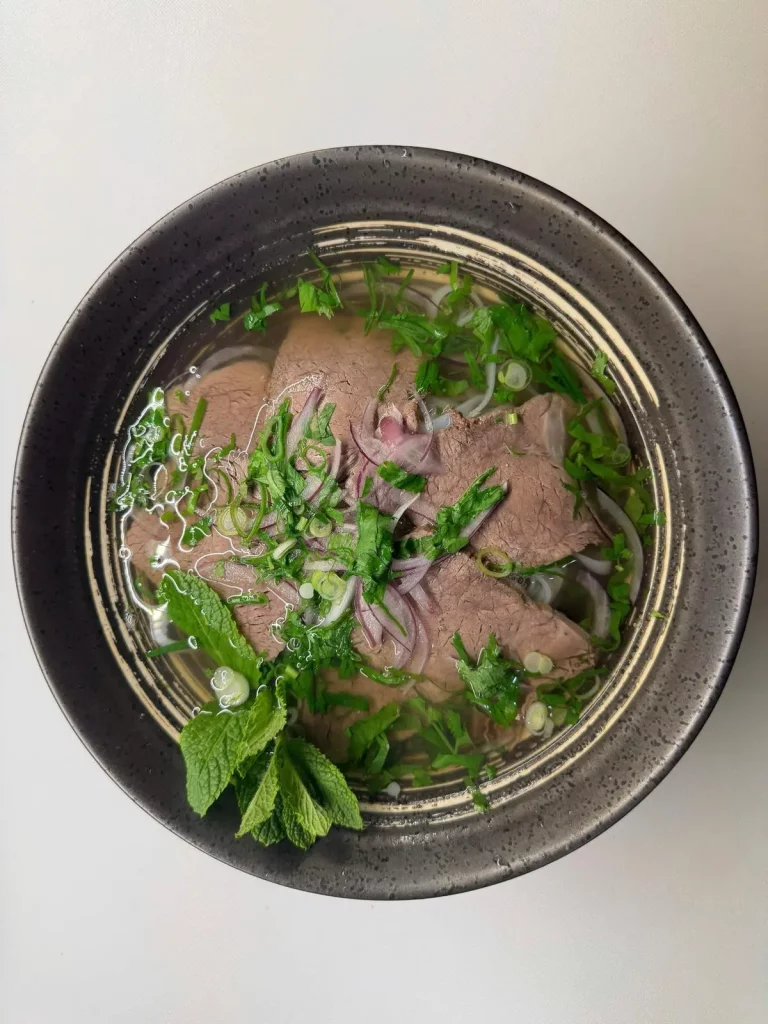 Traditionelle vietnamesische Pho-Nudelsuppe mit Rindfleisch, Kräutern und Reisnudeln bei Do Friends in Hamburg